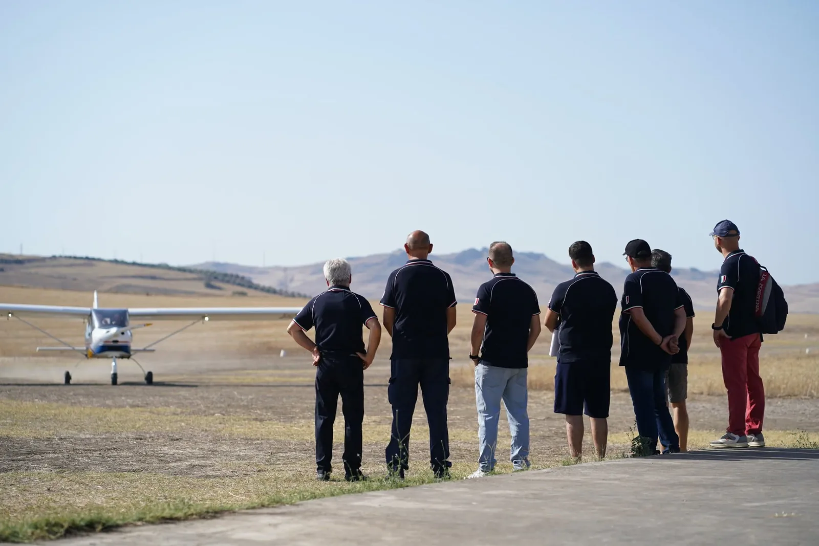 Piloti e allievi della scuola osservano un velivolo rullare sulla pista di Ramacca Margherito